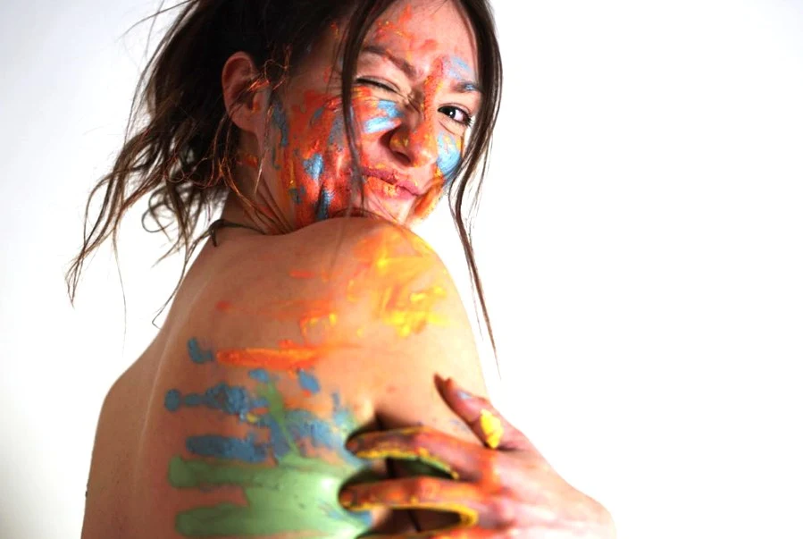 Shalagh looking over her shoulder, covered in paint